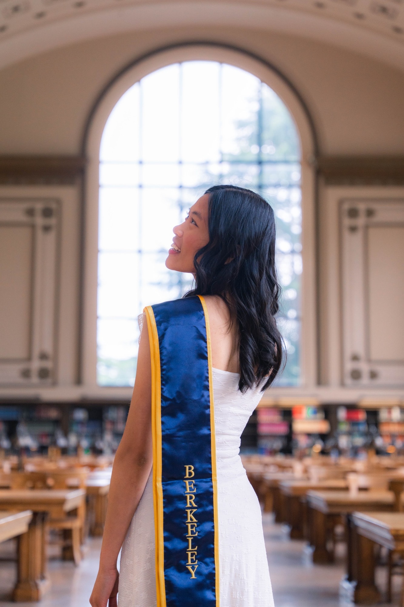 Graduate in the grand reading room, looking back over her shoulder